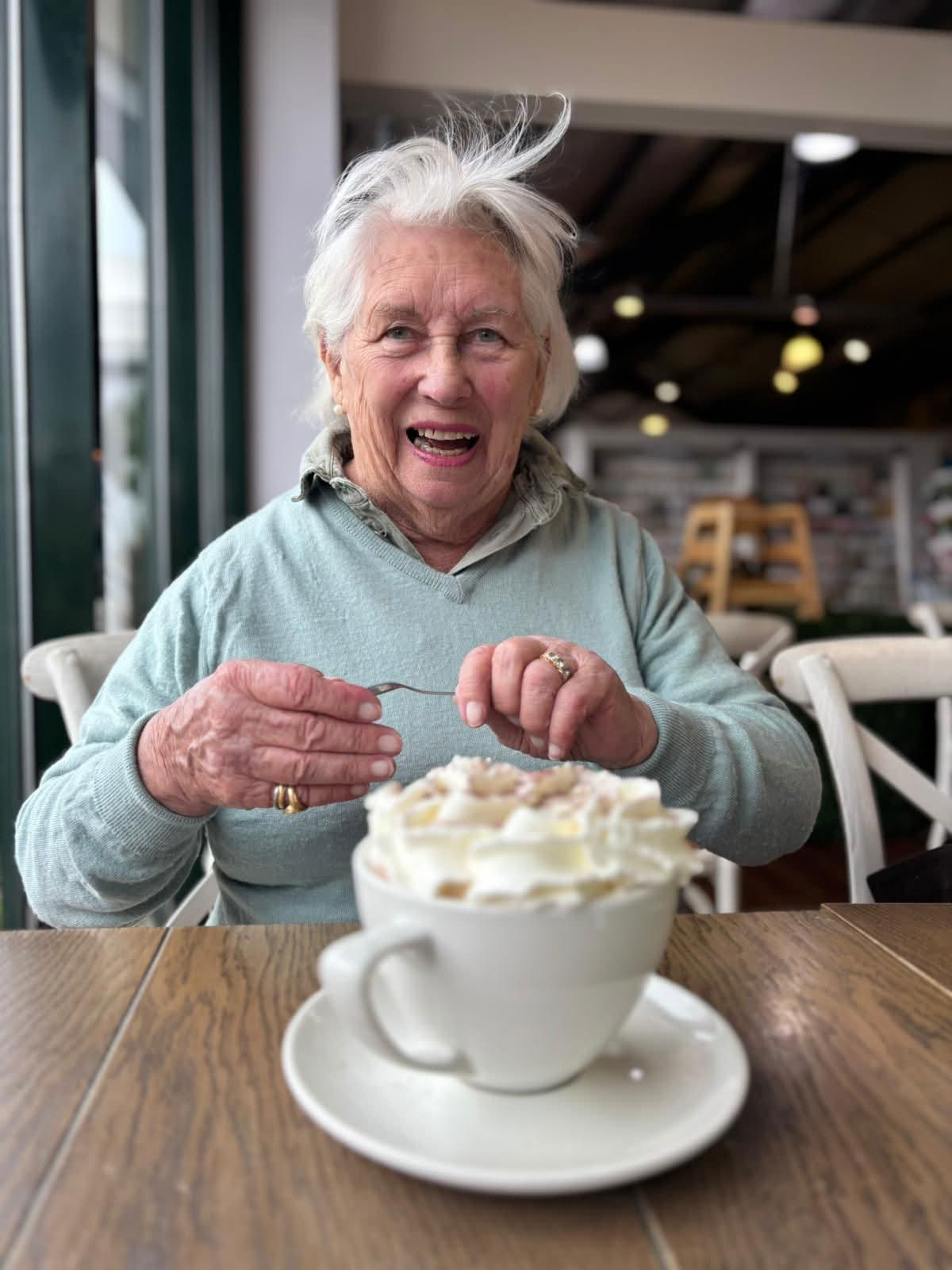 Elderly person enjoying coffee at home — warm, dignified care